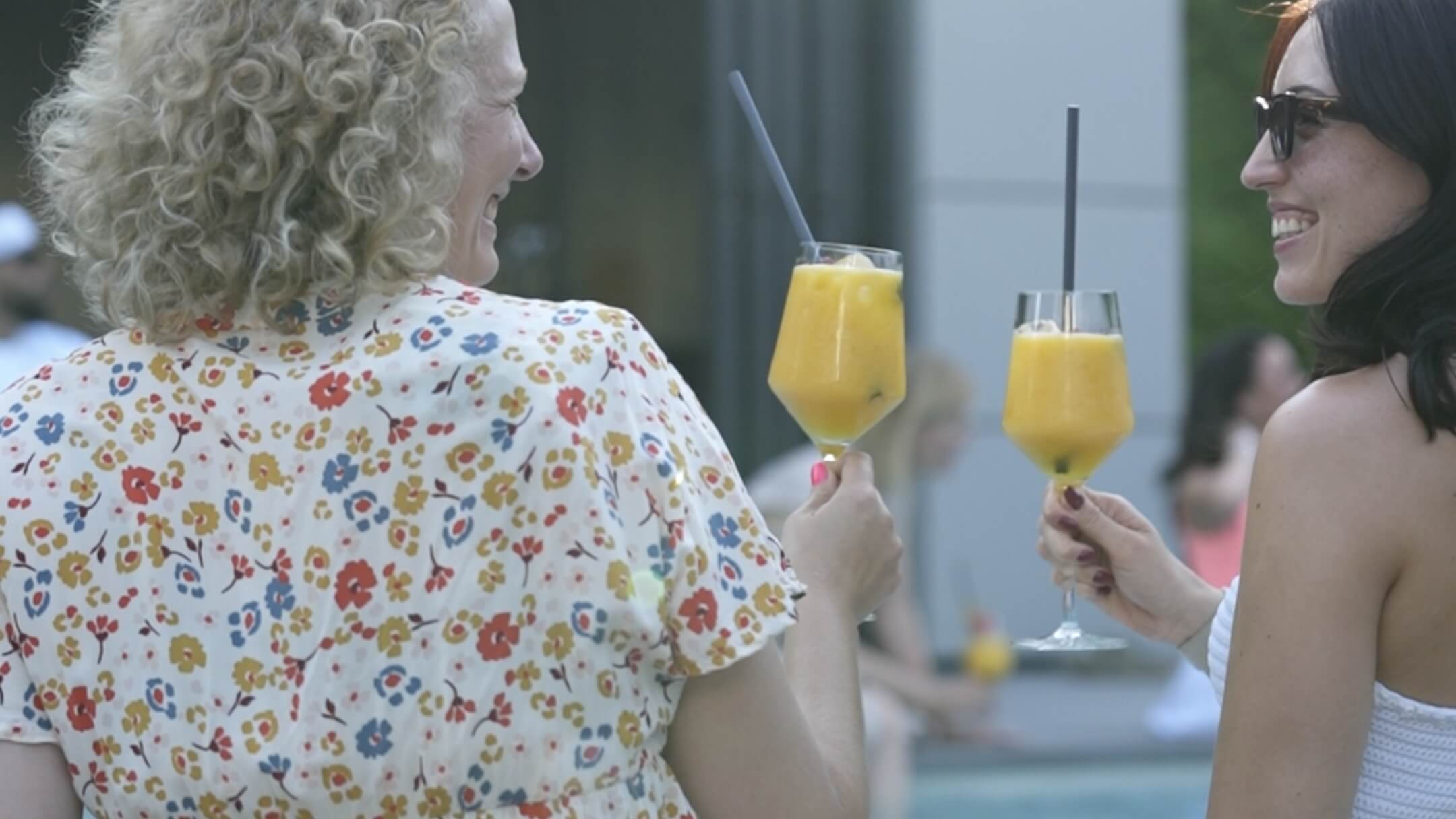 2 Damen trinken am Pool einen Cocktail